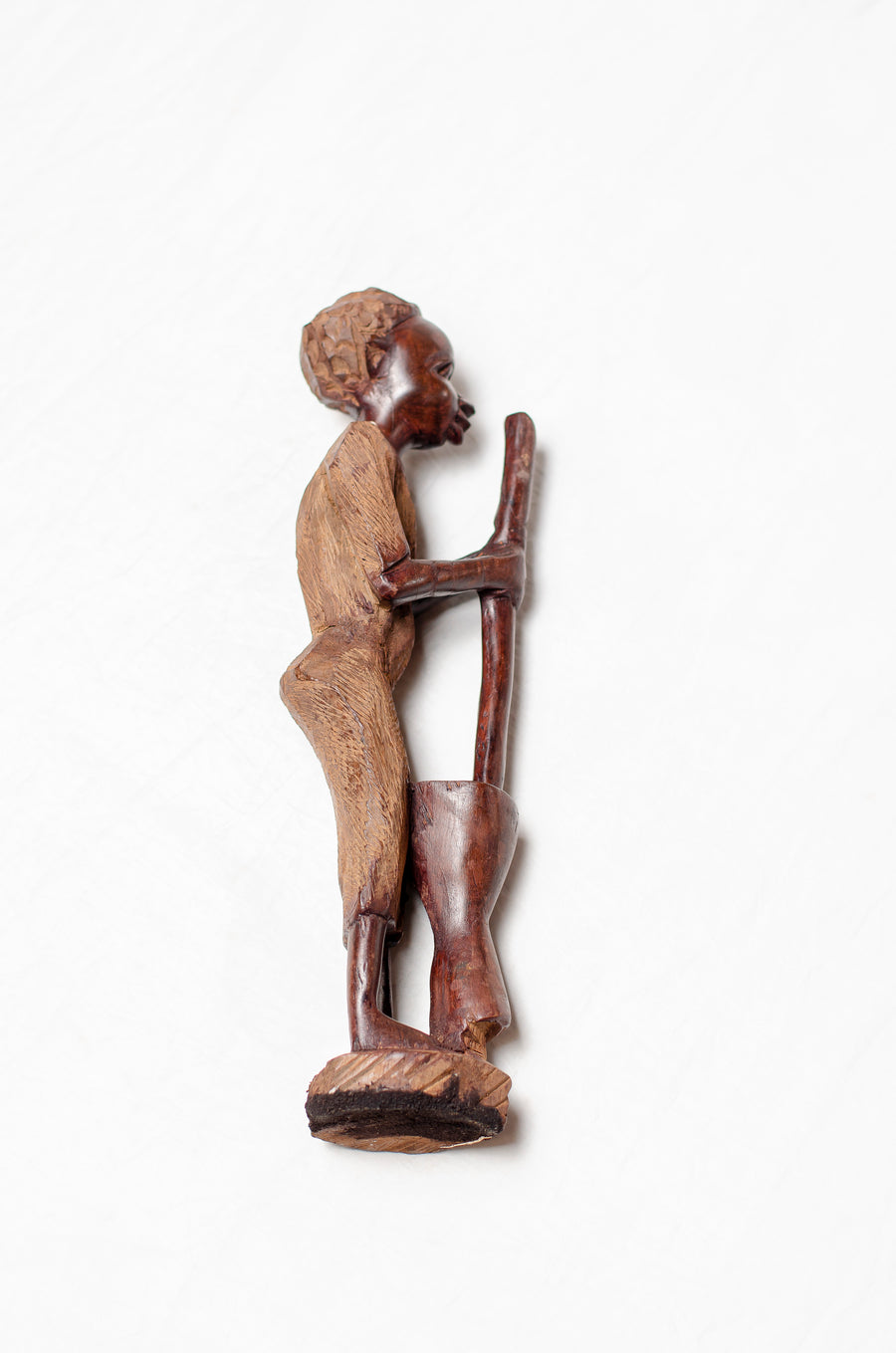 woman pounding wood carving