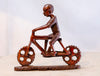 man riding bicycle wooden sculpture