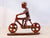 MAN RIDING A BICYCLE MADE OUT OF IRON WOOD